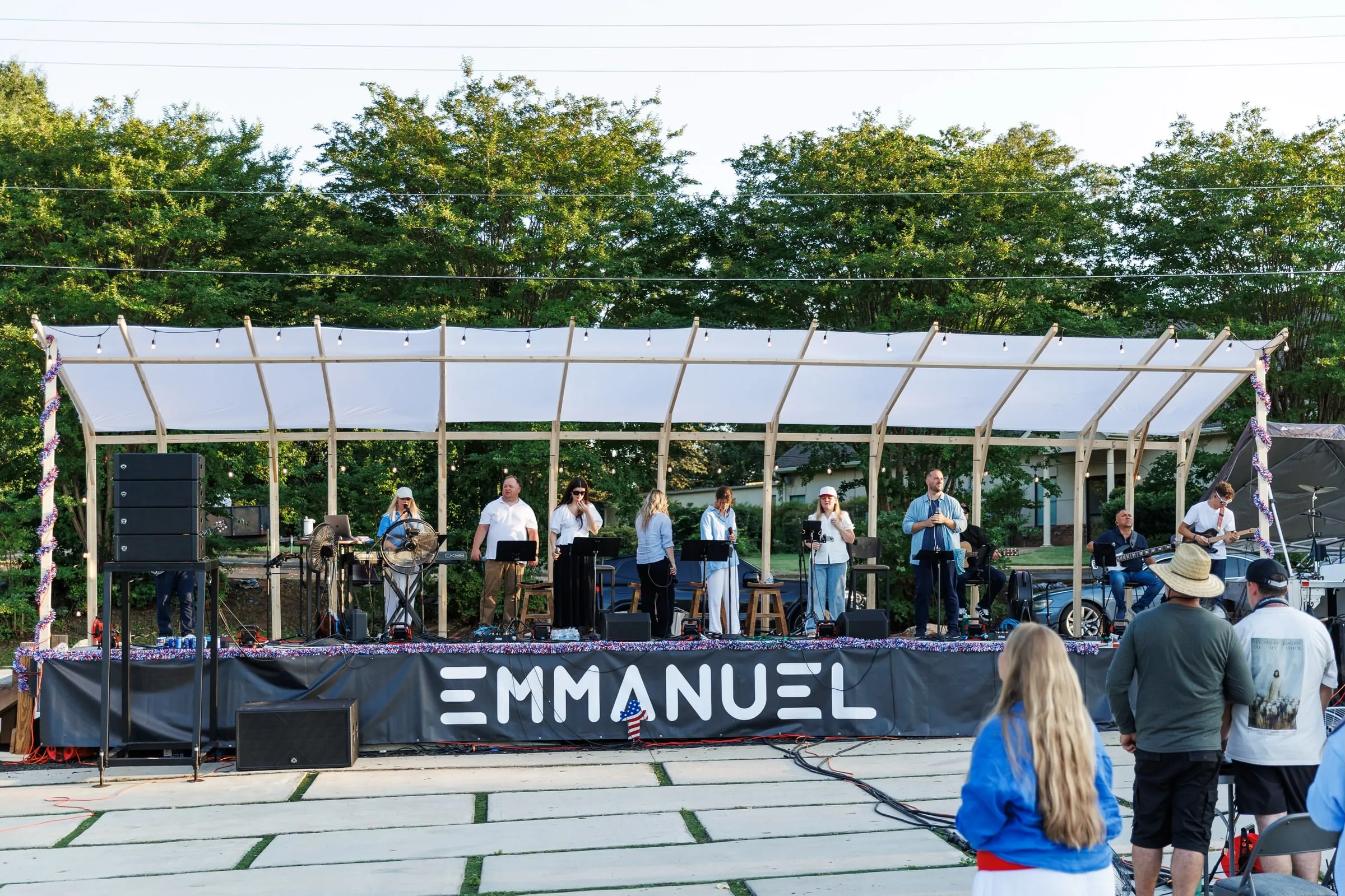 A worship band playing on the covered stage on the lawn at 121 Coffee